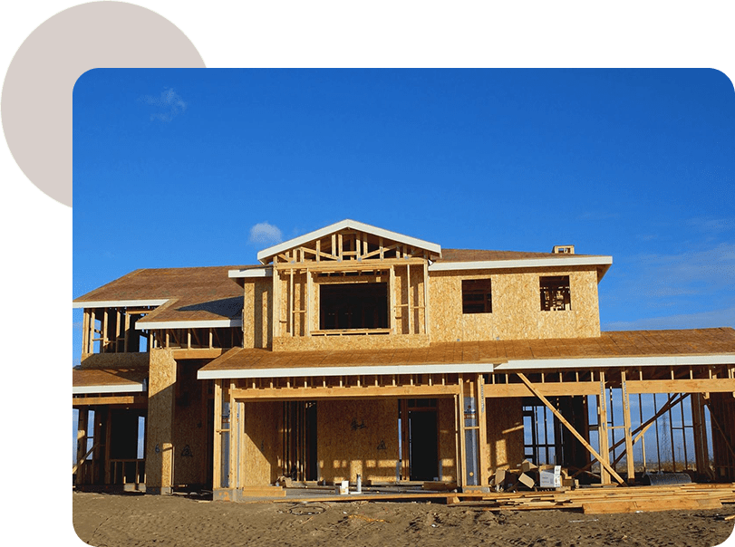 A house under construction with blue sky in the background.